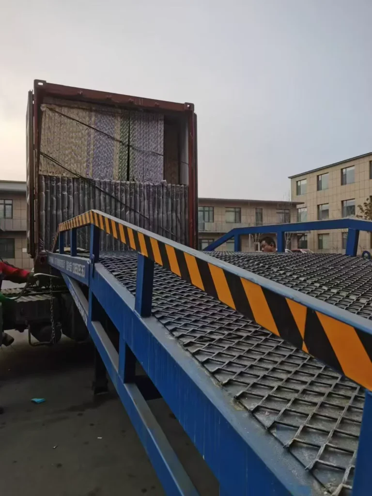 Packed door sets secured inside an export container beside a loading ramp
