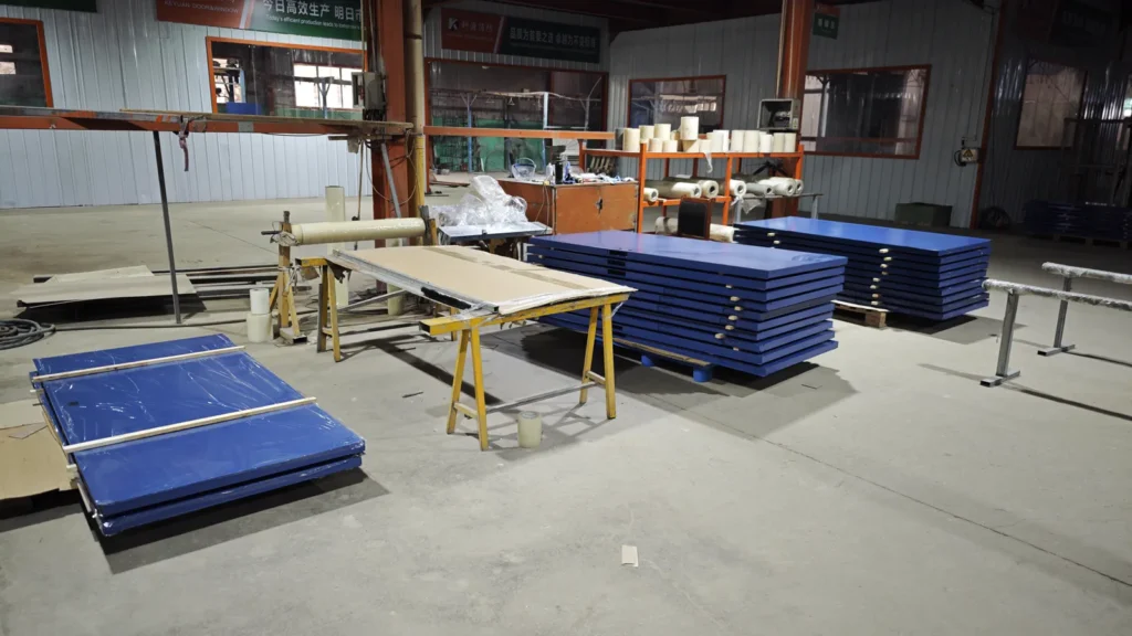 Blue steel door leaves staged on the Bastion Door production floor