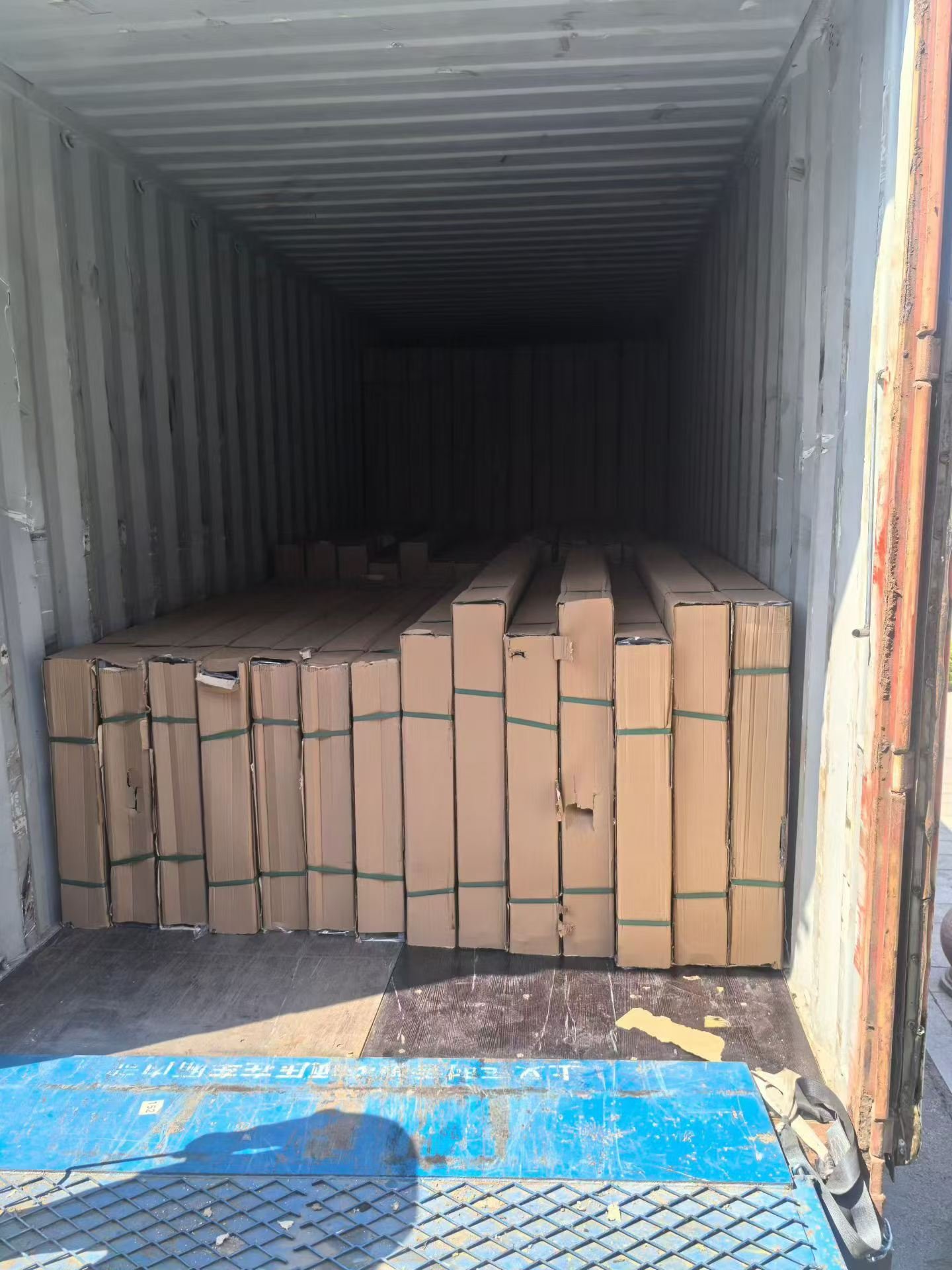 Long protected fire-door and frame packages arranged inside an export container bound for Canada